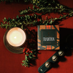 Jackson Vaughn Tradition Holiday Candle with red berries and gold and white lit candle