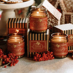 Texas Holiday candles with decorative packaging and berries on a rustic surface